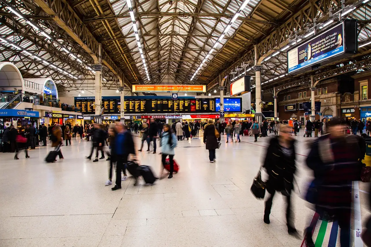 Travellers with bags crossing the busy concourse of London Victoria station