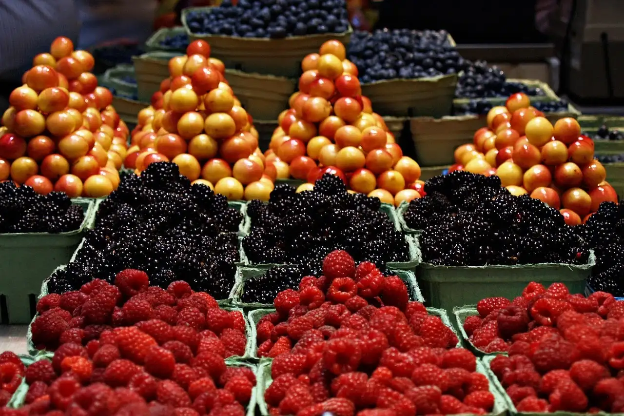 Raspberries, blackberries and peaches piled on a market stall