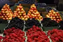 Raspberries, blackberries and peaches piled on a market stall