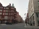 A Mayfair street of red-brick mansion blocks, in the part of London that holds Savile Row