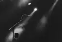 A microphone under a spotlight in a dark, hazy room