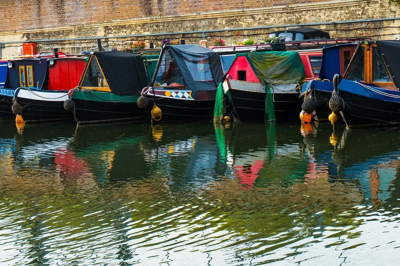 Colourful narrowboats moored side by side on a canal