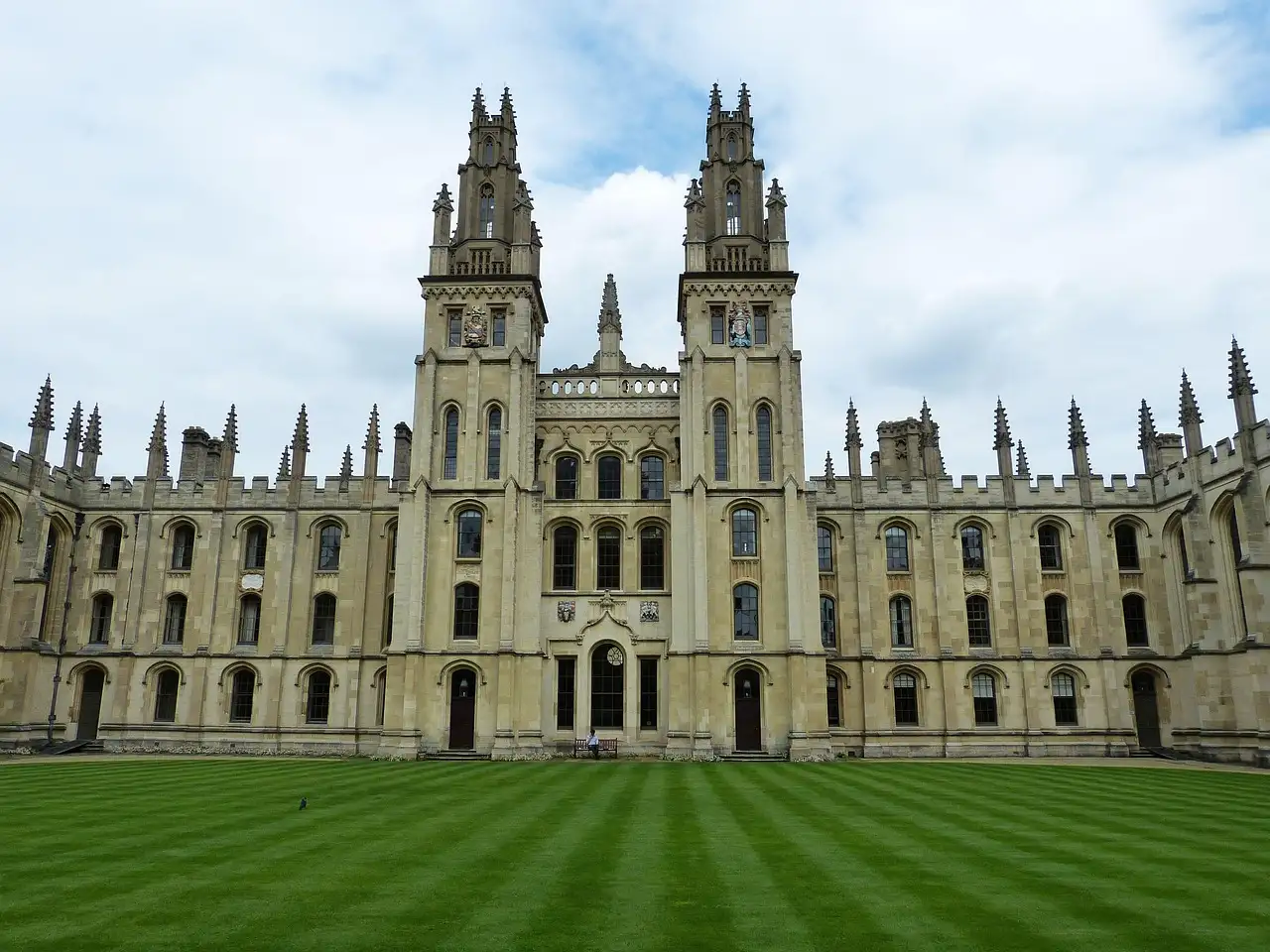 Twin gothic towers of All Souls College in Oxford above a striped lawn