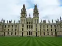 Twin gothic towers of All Souls College in Oxford above a striped lawn