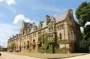 Ivy-covered gothic college building in Oxford under a blue sky