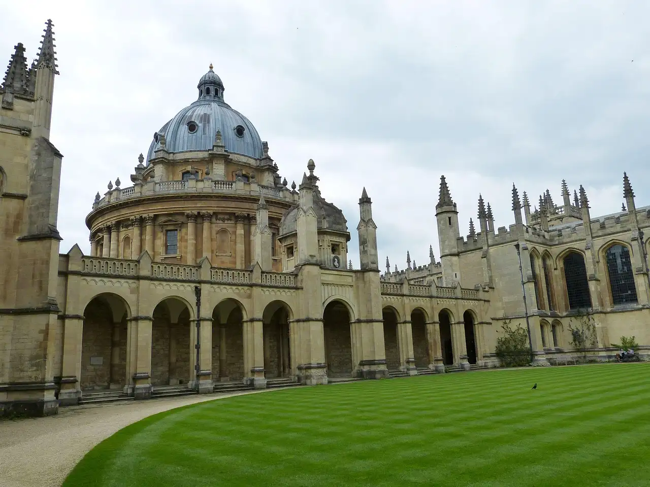 Radcliffe Camera in Oxford seen across a striped college lawn and cloister