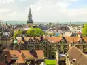 Oxford rooftops and church spires with green hills on the horizon