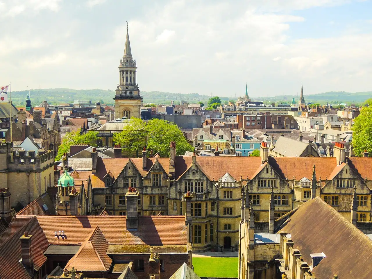 Oxford rooftops and church spires with green hills on the horizon