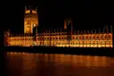 Palace of Westminster lit up at night and reflected in the Thames