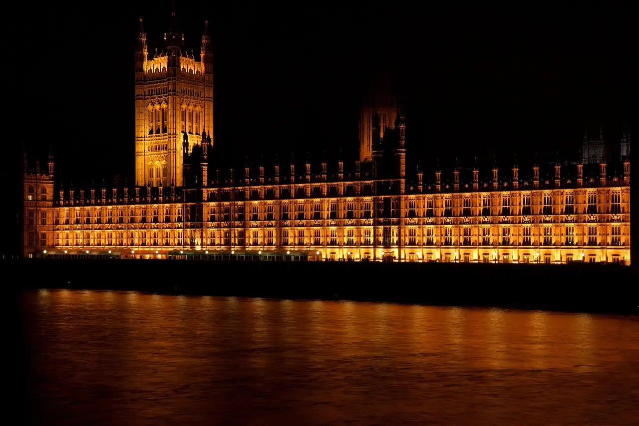 Palace of Westminster lit up at night and reflected in the Thames