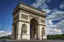 The Arc de Triomphe in Paris under a blue sky with white clouds