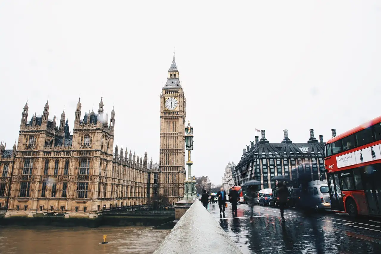 The Houses of Parliament and Big Ben from Westminster Bridge, with a red bus passing
