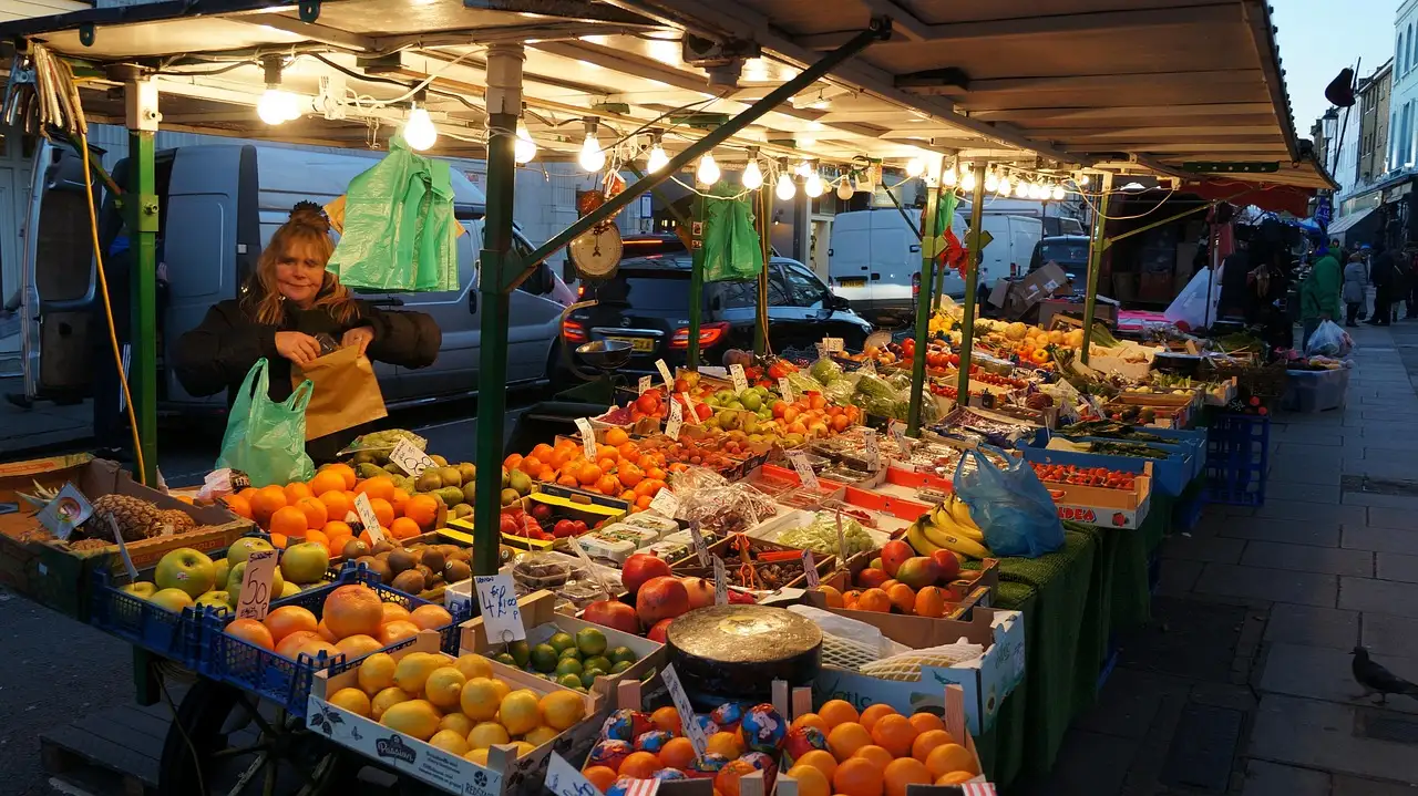 A fruit and vegetable stall on Portobello Road Market under strings of lights