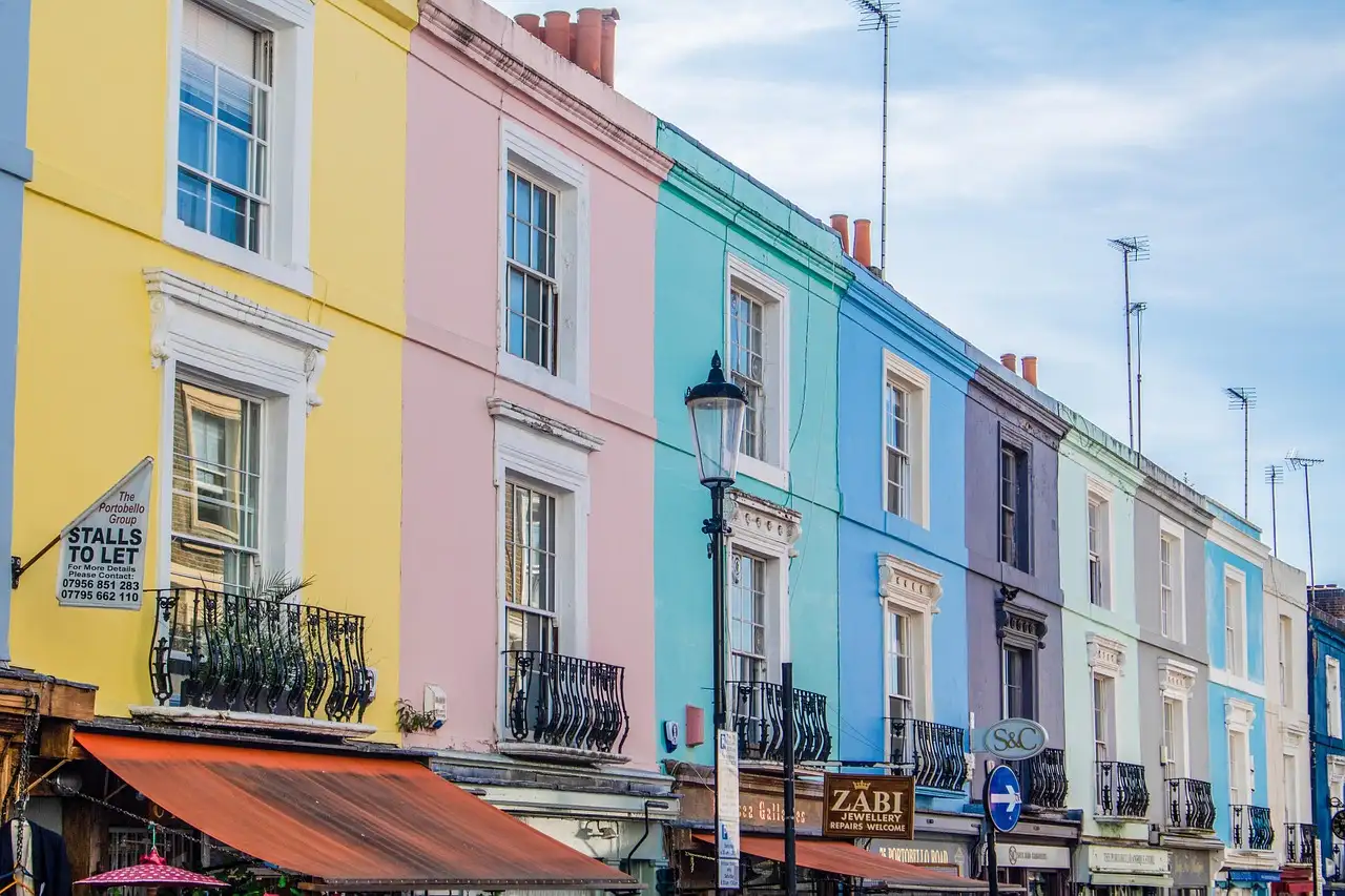Yellow, pink and blue terraced houses on Portobello Road in Notting Hill