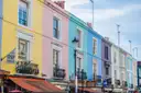 Yellow, pink and blue terraced houses on Portobello Road in Notting Hill
