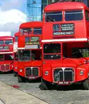 Red double-decker buses parked in a row on a London street