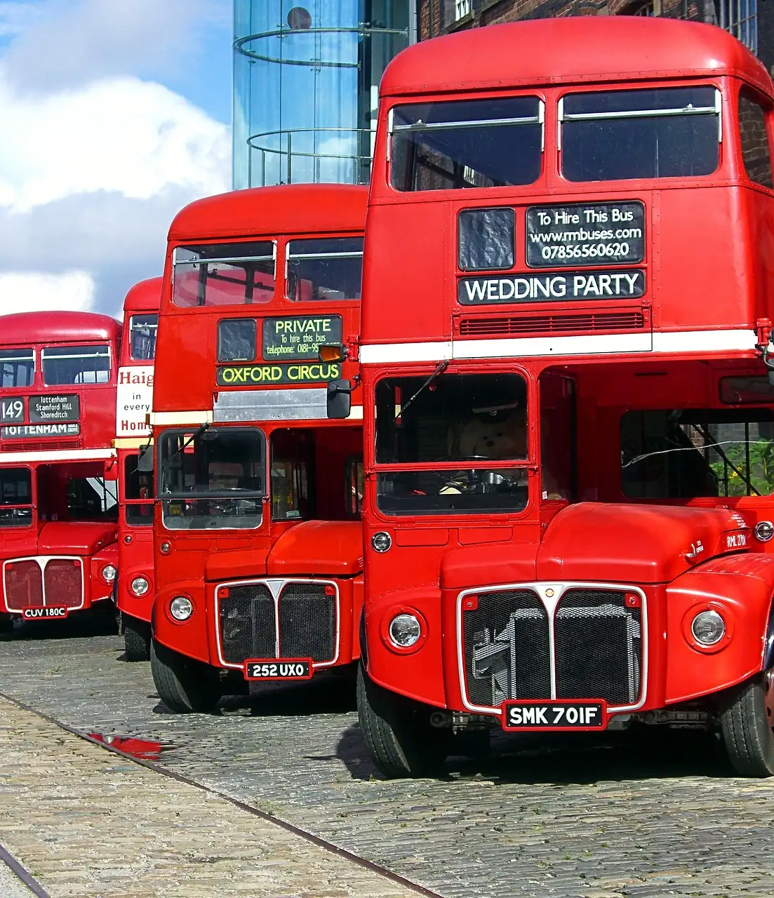 Red double-decker buses parked in a row on a London street