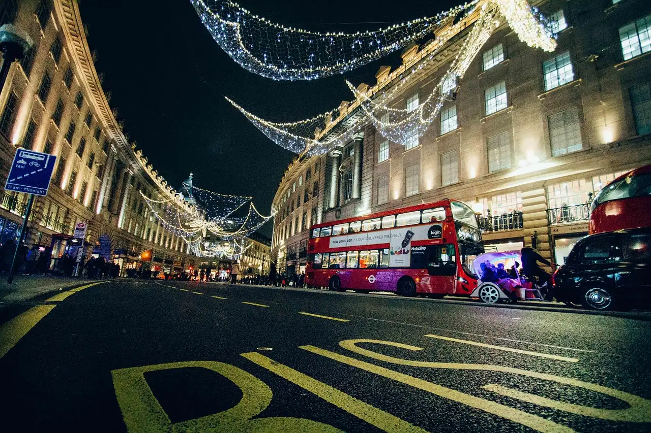 Christmas lights over Regent Street at night with red buses below