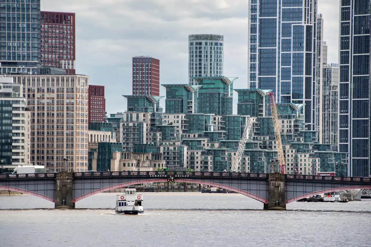 A white river boat on the Thames passing under Lambeth Bridge