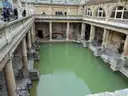 The Roman Baths' green pool and stone columns seen from the terrace