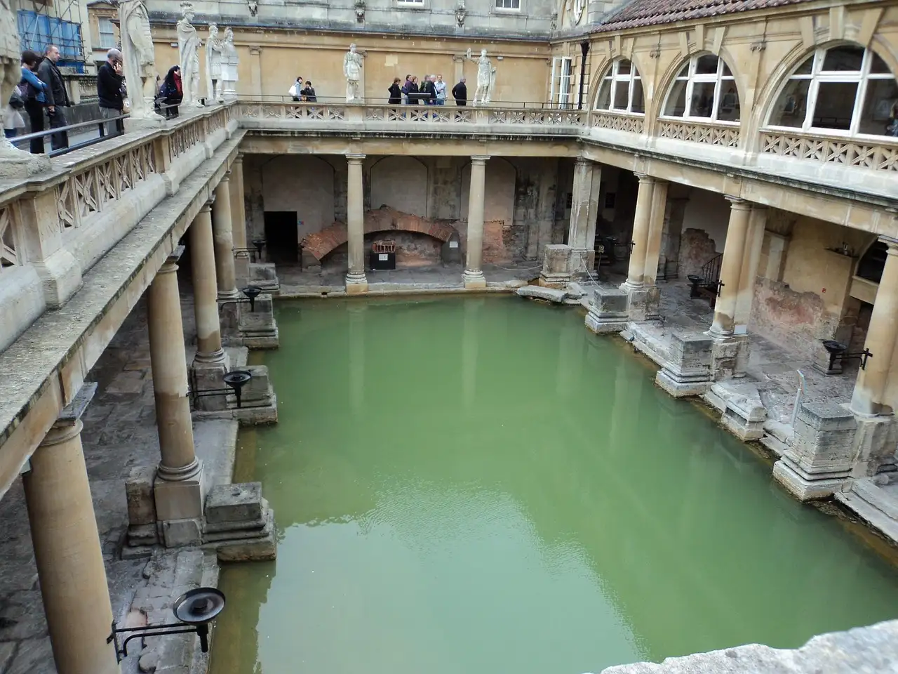 The Roman Baths' green pool and stone columns seen from the terrace
