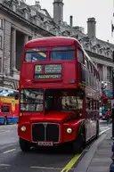 A vintage red Routemaster double-decker bus on a London street