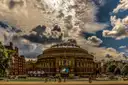 The Royal Albert Hall in Kensington under a dramatic cloudy sky