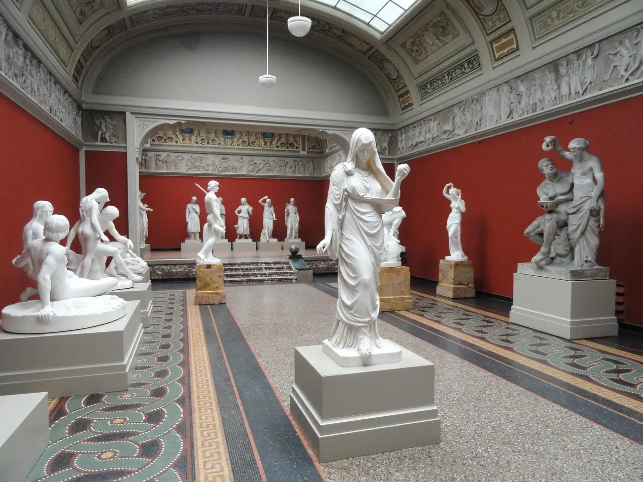 A sculpture hall with red walls and white marble statues