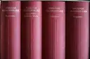 Four red volumes of Shakespeare's works side by side