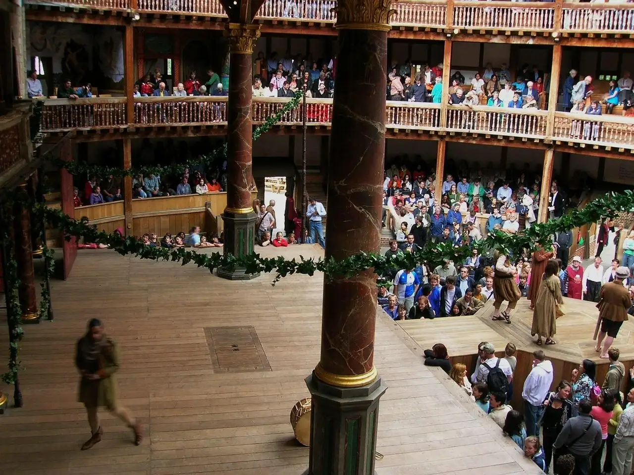 Inside Shakespeare's Globe, with the yard and wooden galleries full of audience