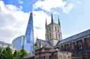 Southwark Cathedral next to the Shard under a blue sky