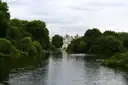 St James's Park lake framed by trees with palace buildings in the distance
