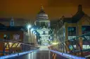 St Paul's Cathedral dome lit at night at the end of a bridge walkway