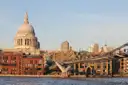 St Paul's Cathedral dome above riverside buildings and the Millennium Bridge