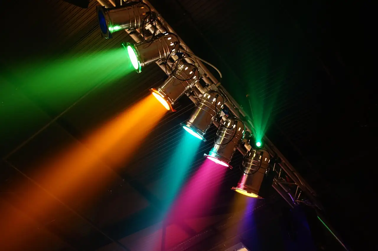 A row of stage spotlights throwing coloured beams