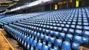 Rows of empty blue seats at Stamford Bridge, seen from pitch side