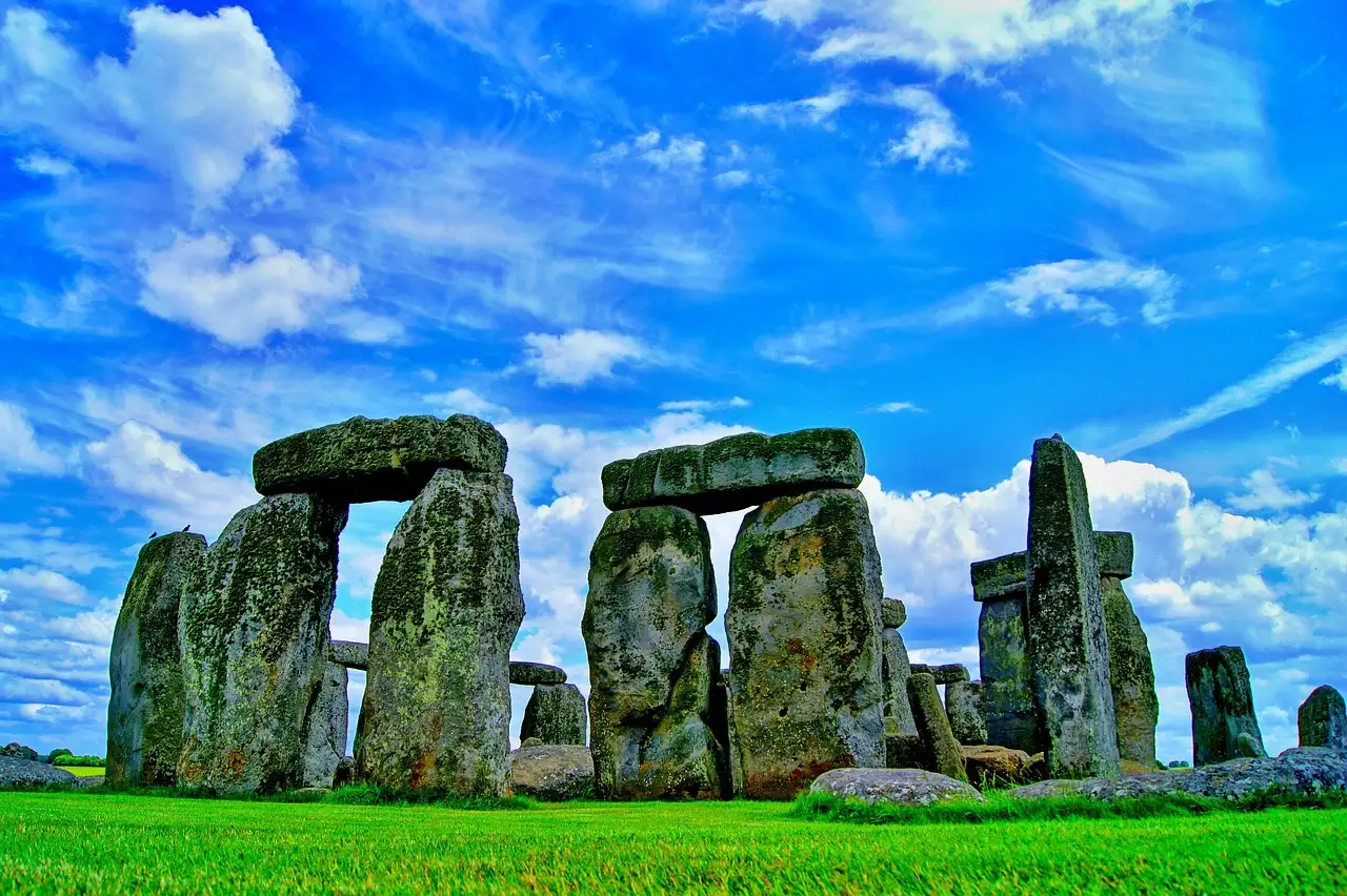 Stonehenge on green grass under a deep blue sky