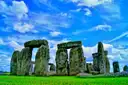 Stonehenge on green grass under a deep blue sky