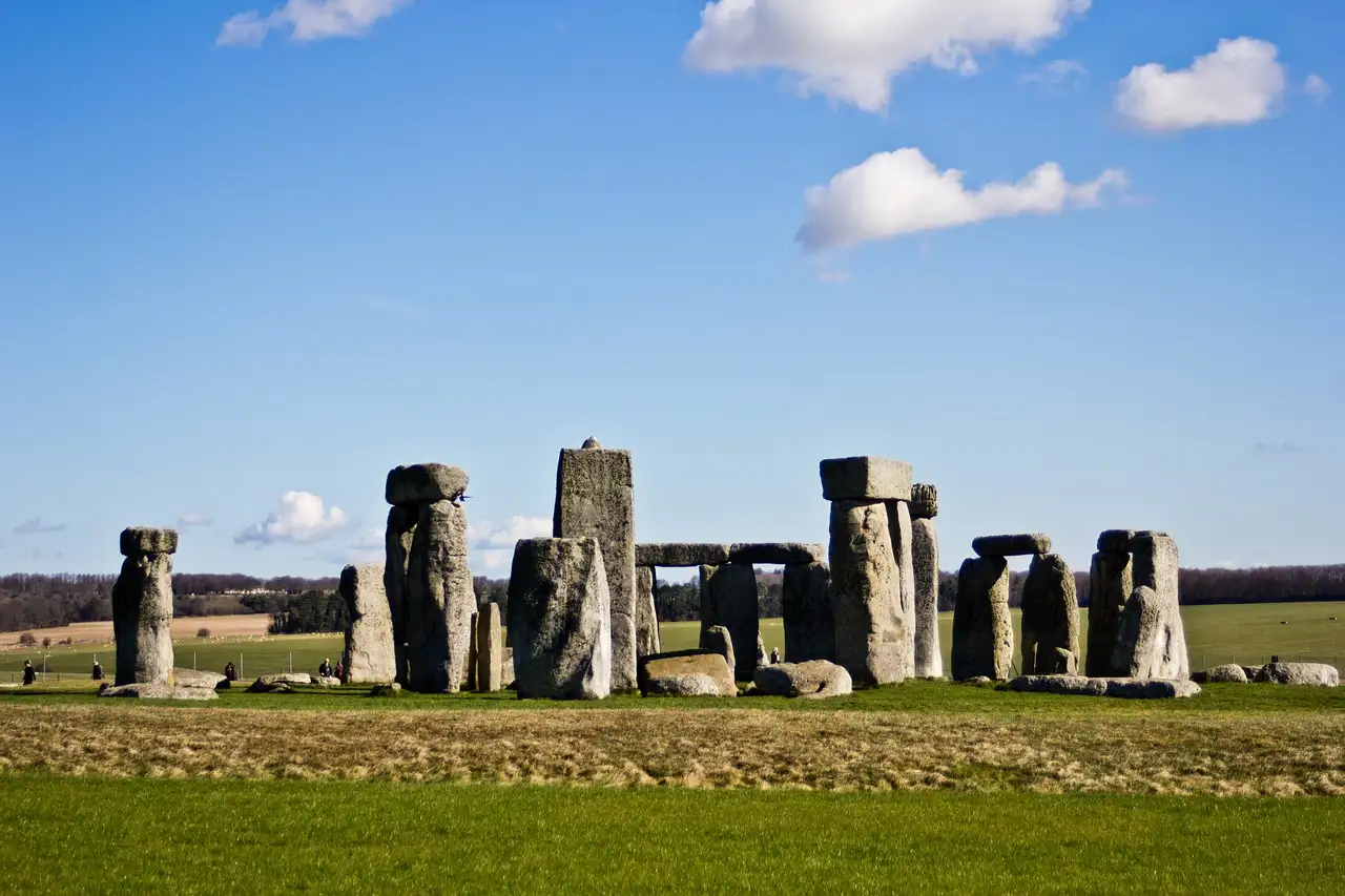 Stonehenge stone circle on green grass under a blue sky