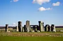 Stonehenge stone circle on green grass under a blue sky