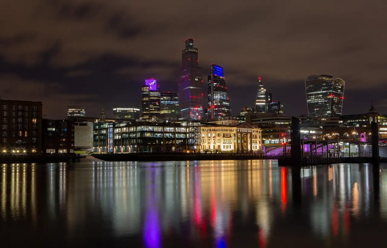 The City of London lit up at night and reflected in the Thames