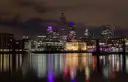 The City of London lit up at night and reflected in the Thames