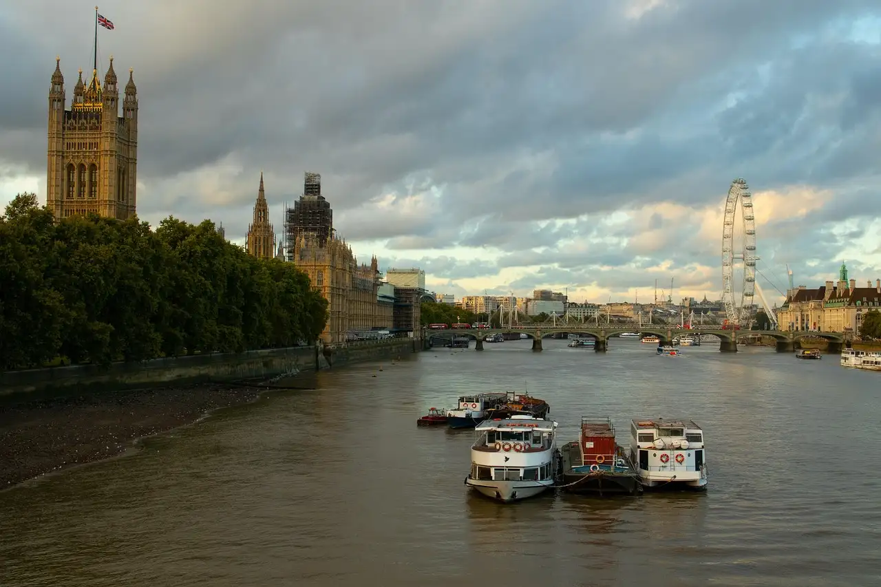 River boats on the Thames at Westminster with the Houses of Parliament and the London Eye behind