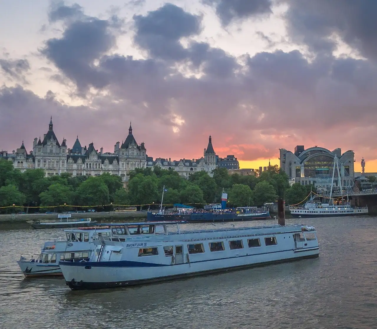Two white sightseeing boats on the Thames at sunset