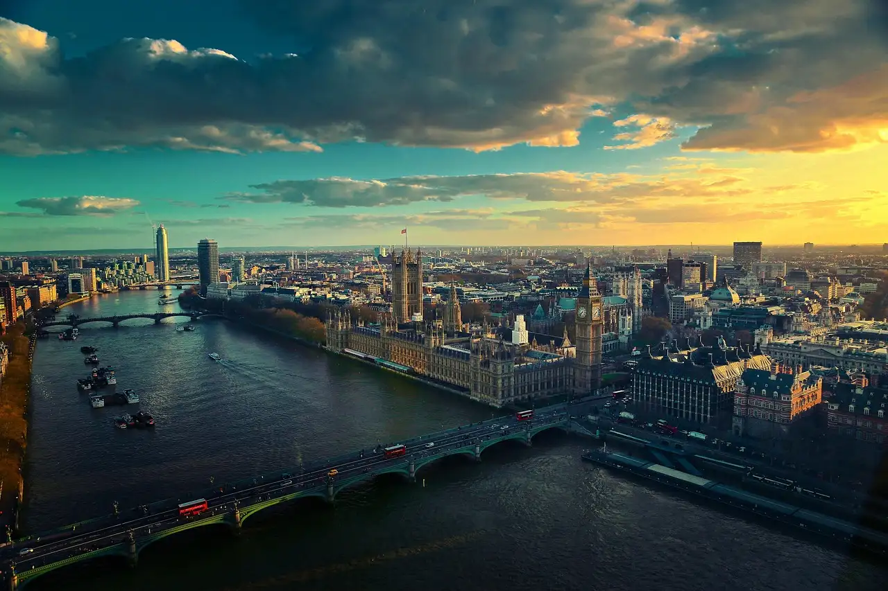 Aerial view of the River Thames and Westminster at sunset, with London stretching to the horizon