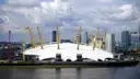 The white O2 dome across the Thames with Canary Wharf behind