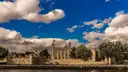 Tower of London on the riverside under a blue sky with large white clouds