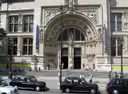 The ornate main entrance of the Victoria and Albert Museum, with black cabs in front