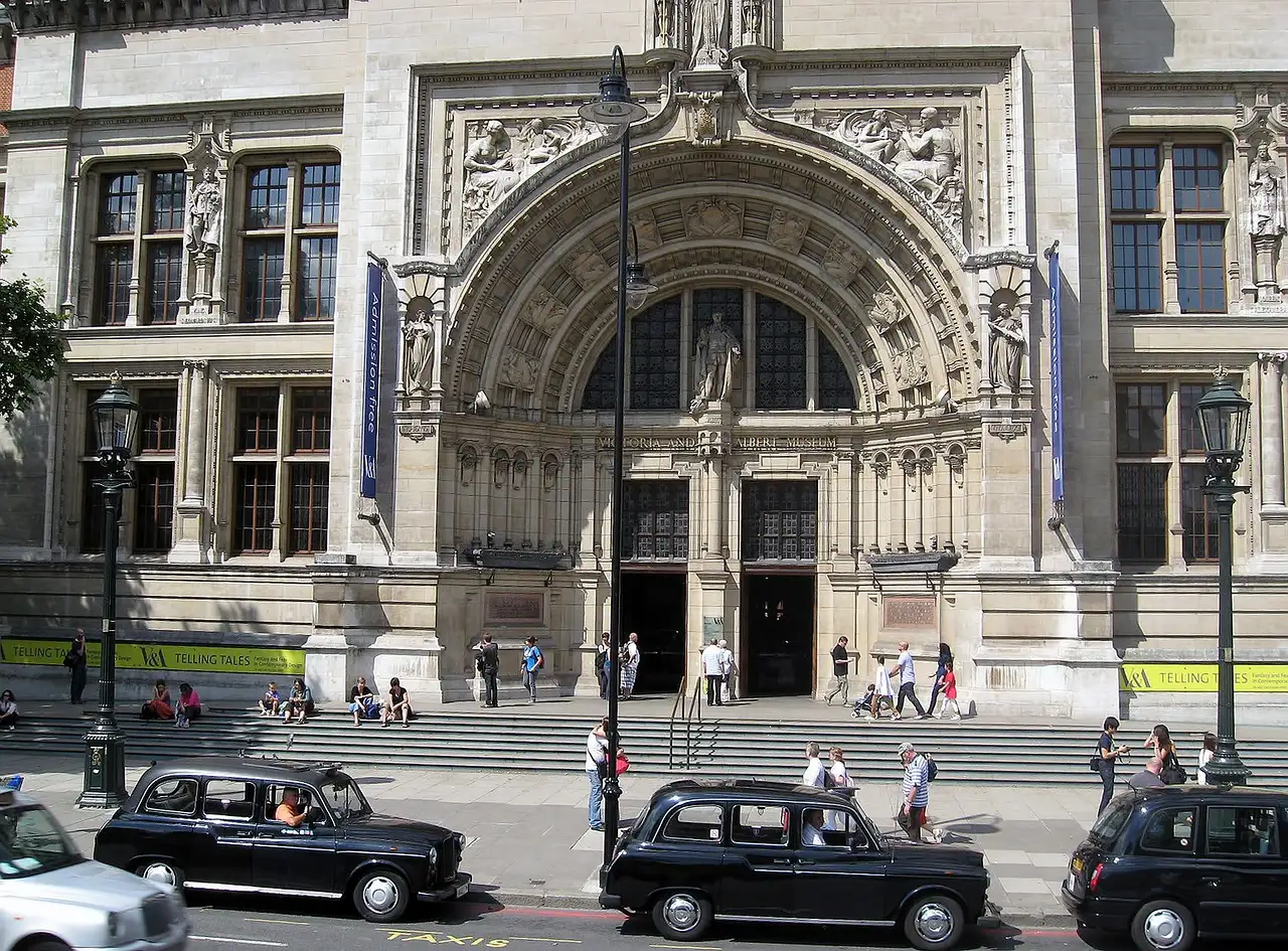 The ornate main entrance of the Victoria and Albert Museum, with black cabs in front