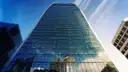 Looking up at the curved glass Walkie-Talkie tower against a blue sky